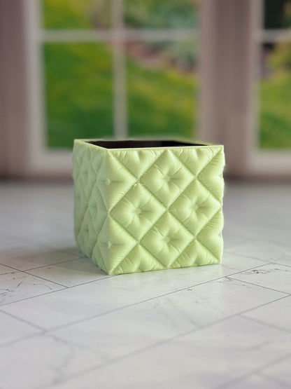 Mint green pillow-style mini planter holding a small houseplant, designed to fit a 2 inch nursery pot