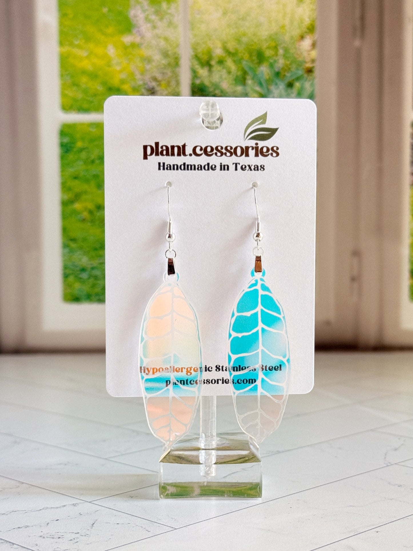 Hand-drawn and laser-cut iridescent Hoya callistophylla leaf earrings with stainless steel hooks.