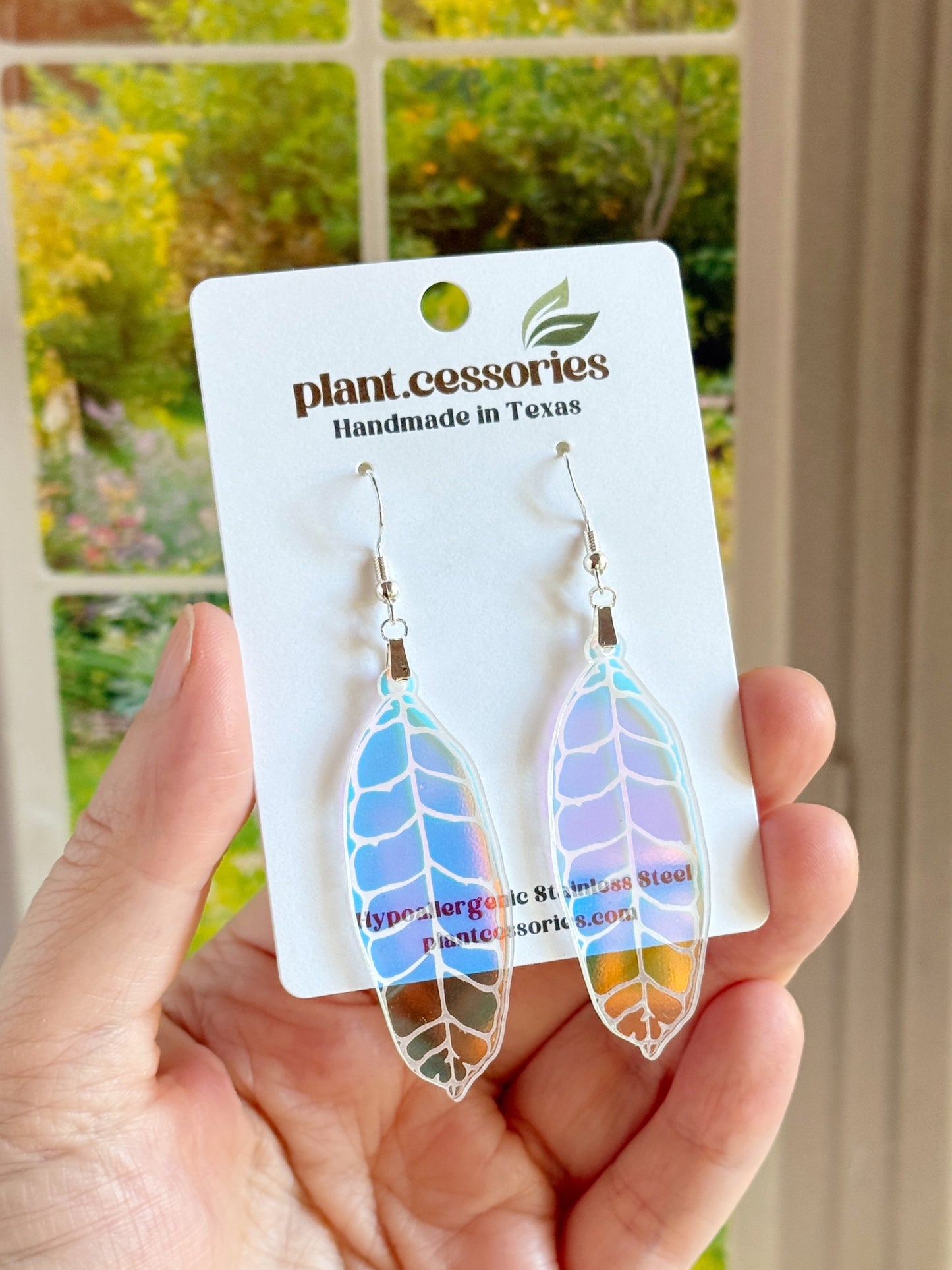 Hand-drawn and laser-cut iridescent Hoya callistophylla leaf earrings with stainless steel hooks.
