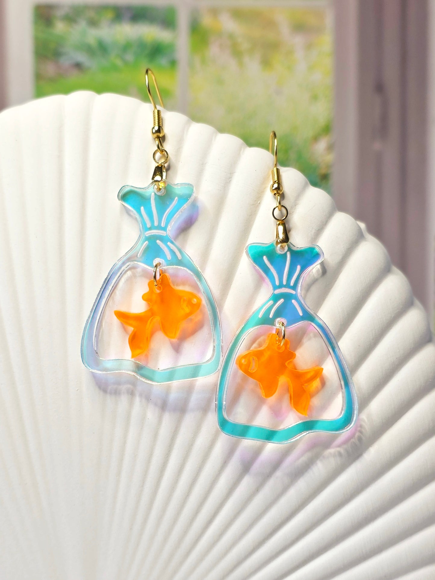 Handmade goldfish bag earrings featuring iridescent acrylic fish bags with translucent orange goldfish charms and hypoallergenic stainless steel ear wires.