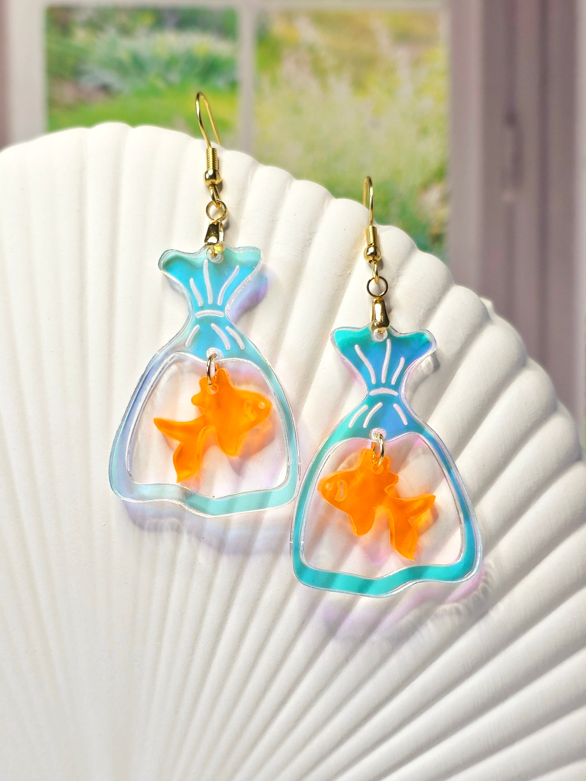 Handmade goldfish bag earrings featuring iridescent acrylic fish bags with translucent orange goldfish charms and hypoallergenic stainless steel ear wires.