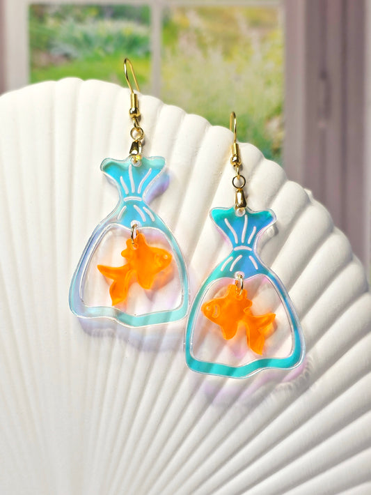 Handmade goldfish bag earrings featuring iridescent acrylic fish bags with translucent orange goldfish charms and hypoallergenic stainless steel ear wires.