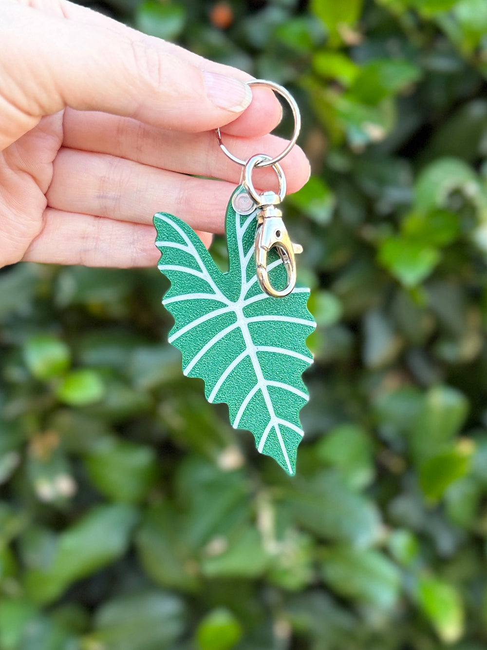 Green and pink Alocasia Amazonica leaf keychains and bag charms 3D printed from plant-based PLA.