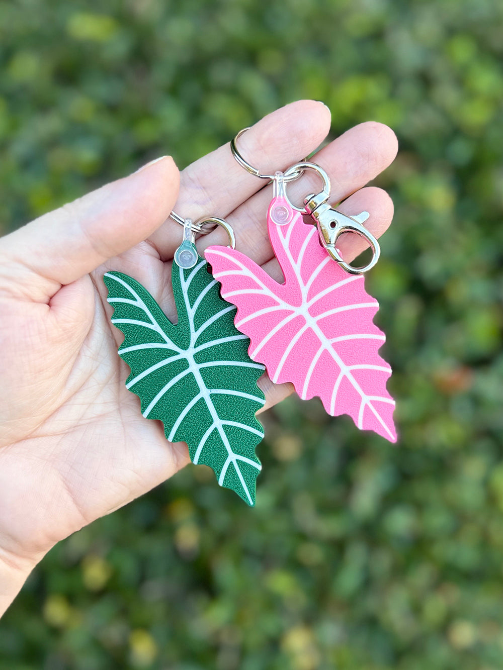 Green and pink Alocasia Amazonica leaf keychains and bag charms 3D printed from plant-based PLA.